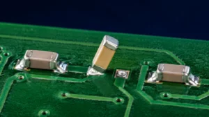 Tombstoned chip capacitor with one end lifted above its PCB pad beside normally soldered components
